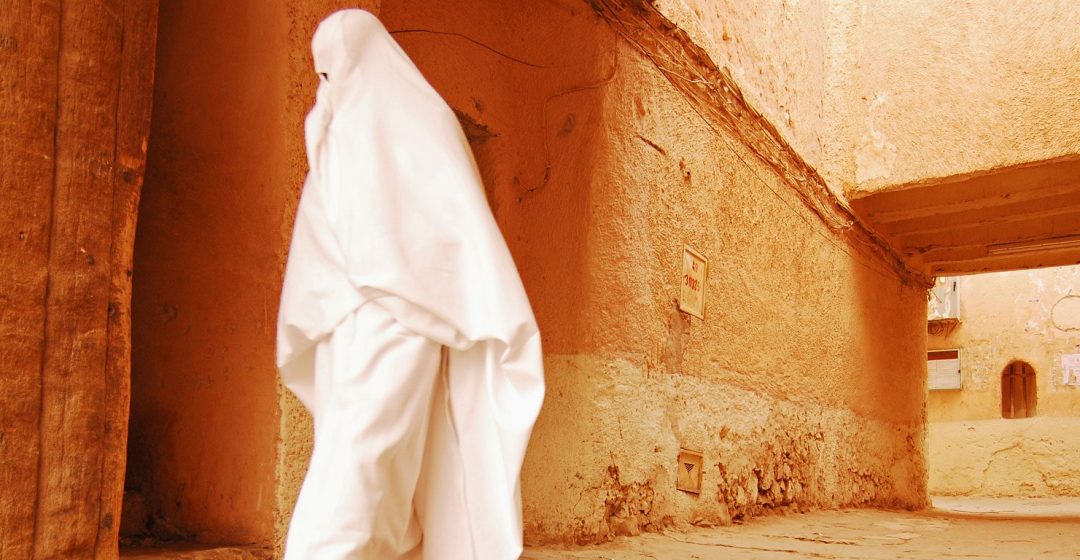 Woman walking through narrow streets of Ghardaia, Algeria