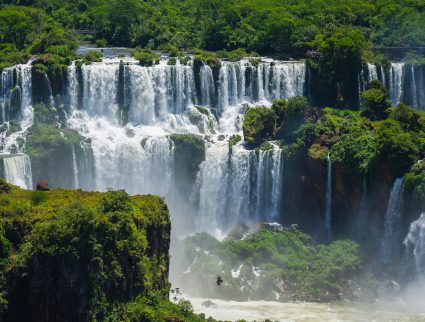 Water cascades down through rain forest vegetation at Iguaza Falls, Argentina