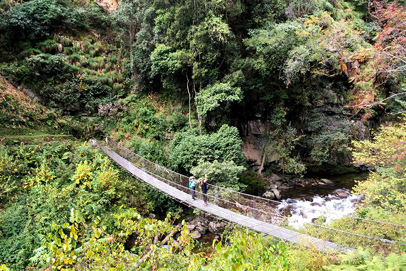 Hikers crossing a bridge on the Hidden Highlands trek in Bhutan