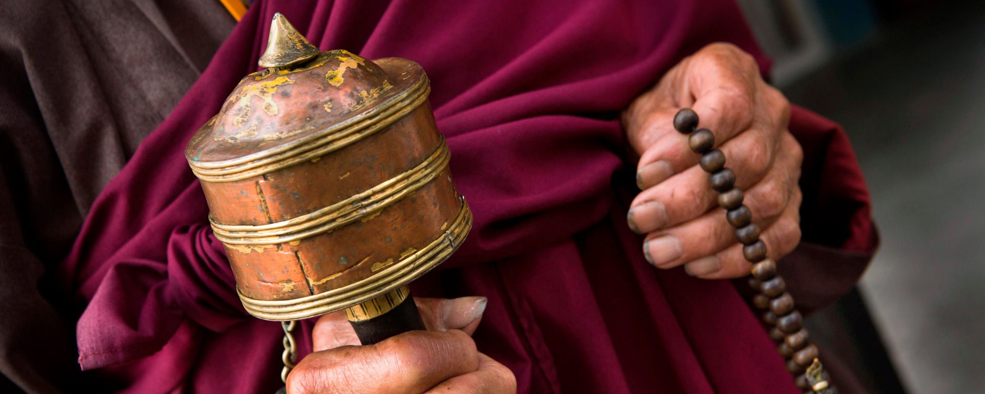 Hands of old monk holding prayer wheel and beads, Rangjung Monastery, Trashigang, Eastern Bhutan