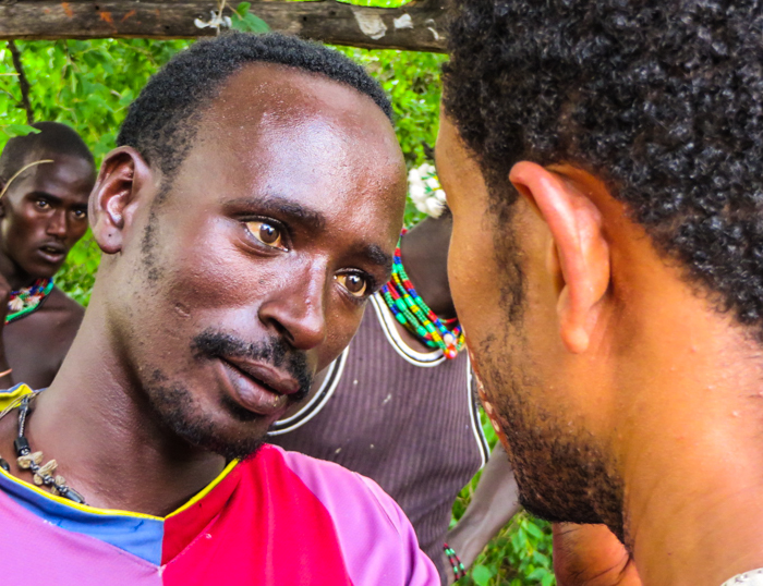 A guide paints the face of a friend in the Omo Valley in Ethiopia with GeoEx.