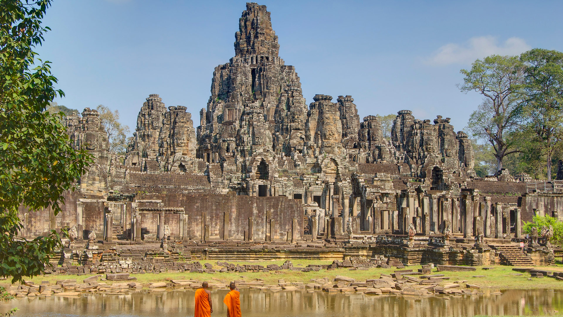 Monks looking at Bayon Temple, part of the Angkor UNESCO site, Cambodia with GeoEx