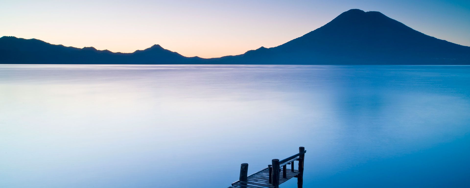 A wooden pier over Santa Cruz La Laguna, with mountain in the background, Lake Atitlan, Guatemala