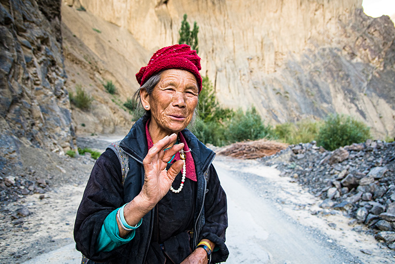 A woman shares a greeting on Mangyu Gorge road in Ladakh, India