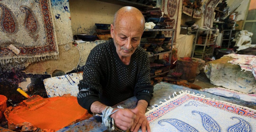 An artist crafts tapestries in his workshop, Iran