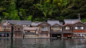 Traditional funaya residences set against lush greenery in Ine, Japan