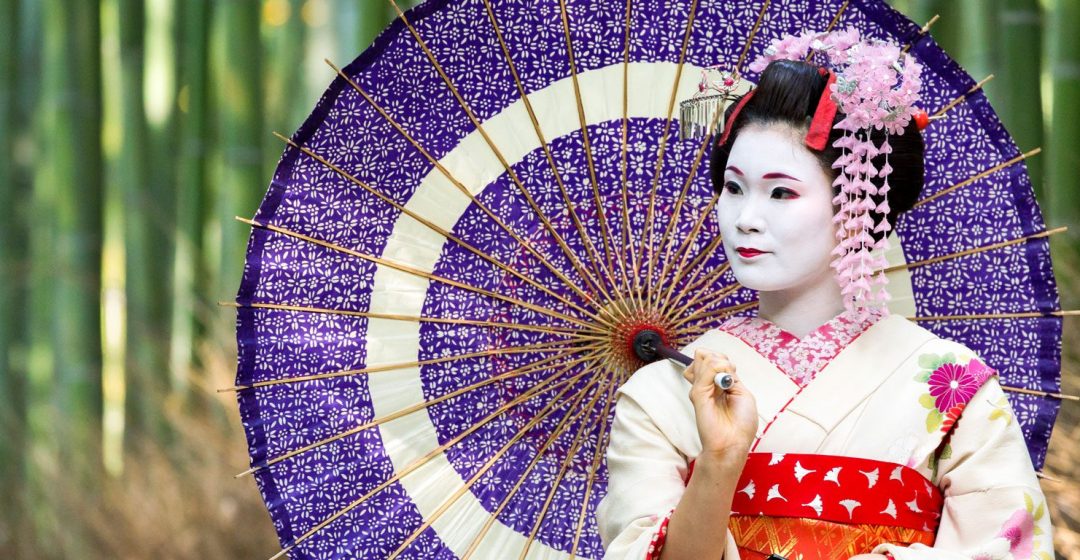 Maiko with colorful kimono and umbrella in Arashiyama, Kyoto, Japan