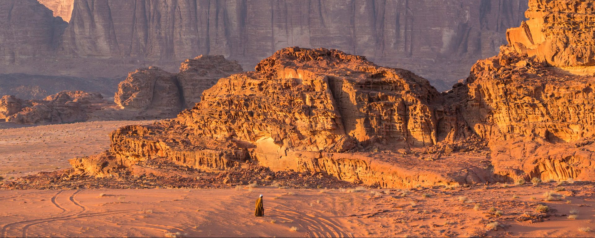 Bedouin man walking across desert, Wadi Rum, Jordan