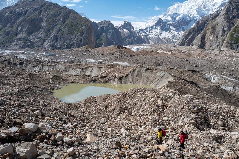 Two trekkers cross a glacier on K2 & Broad Peak Trek, Pakistan