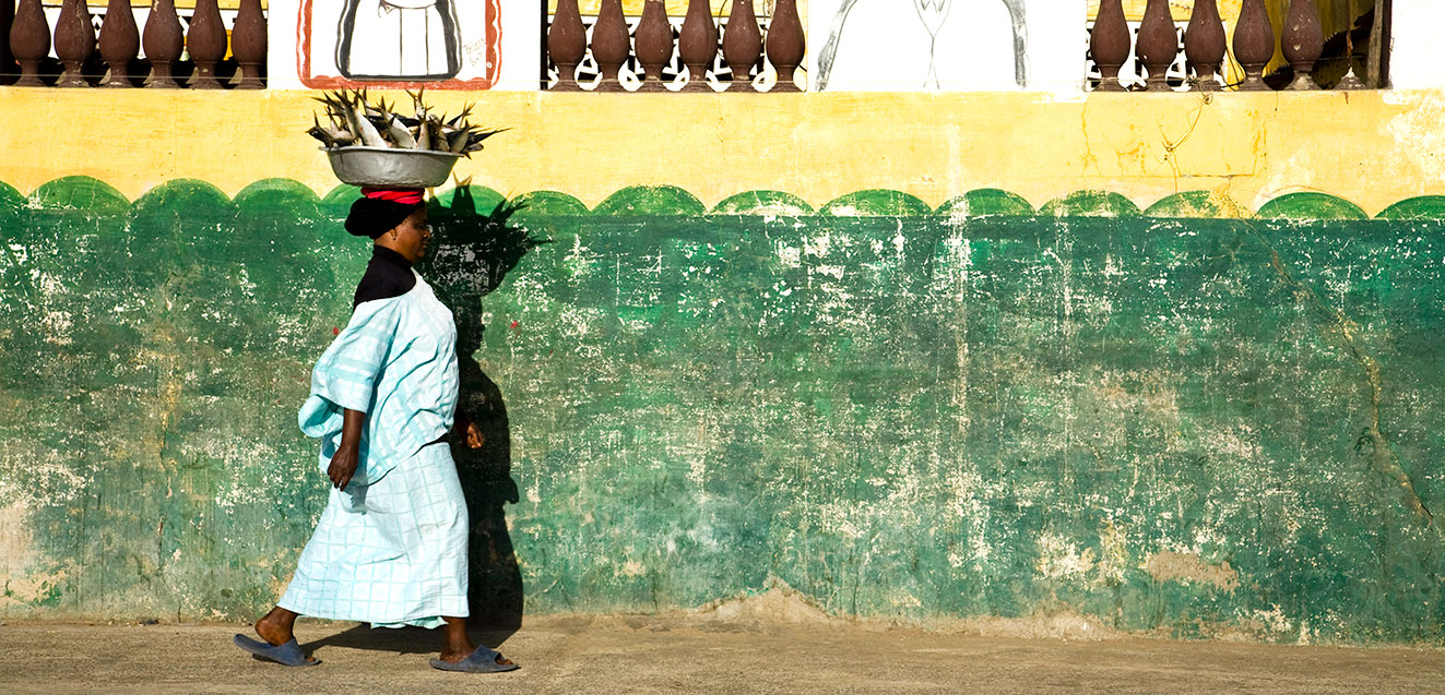 Senegalese woman walking with a large bowl of fresh fish atop her head.