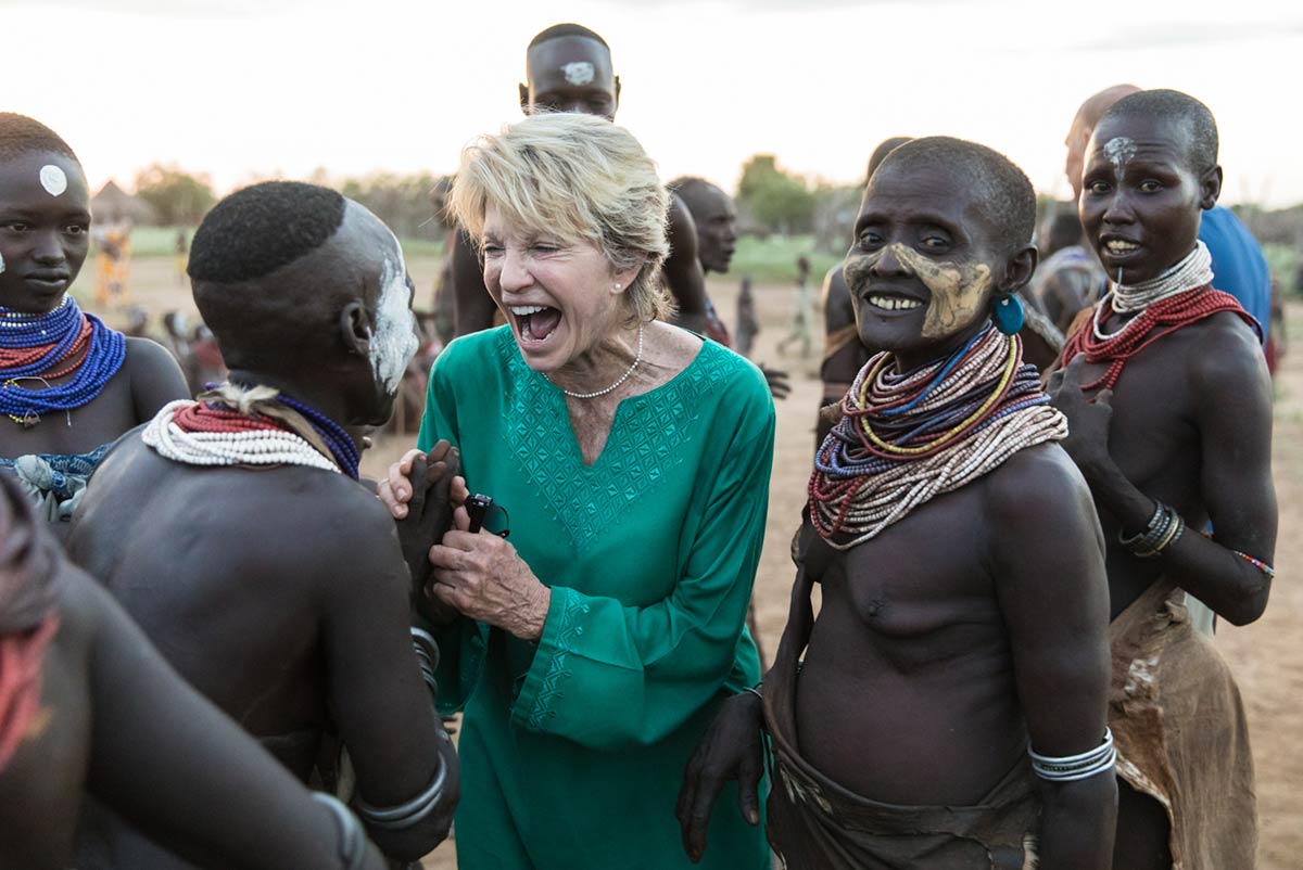 GeoEx traveler getting acquainted with young woman from the Kara tribe, Omo Valley, Ethiopia