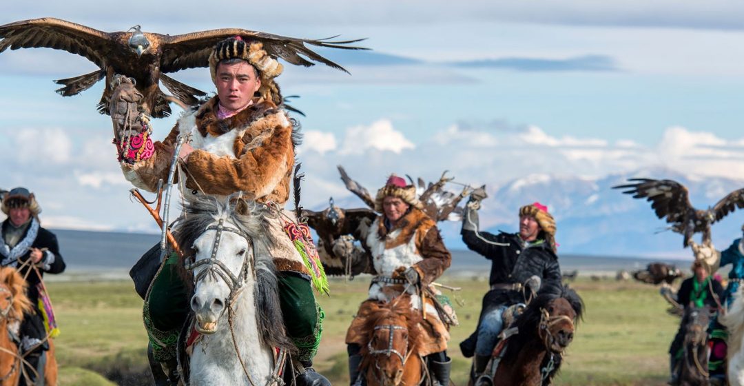 Kazakh eagle hunters on horseback in the the Altai mountains, Mongolia