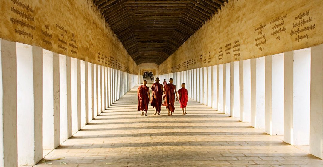 Young monks walking the hallway of Swezigon Pagoda near Bagan, Myanmar