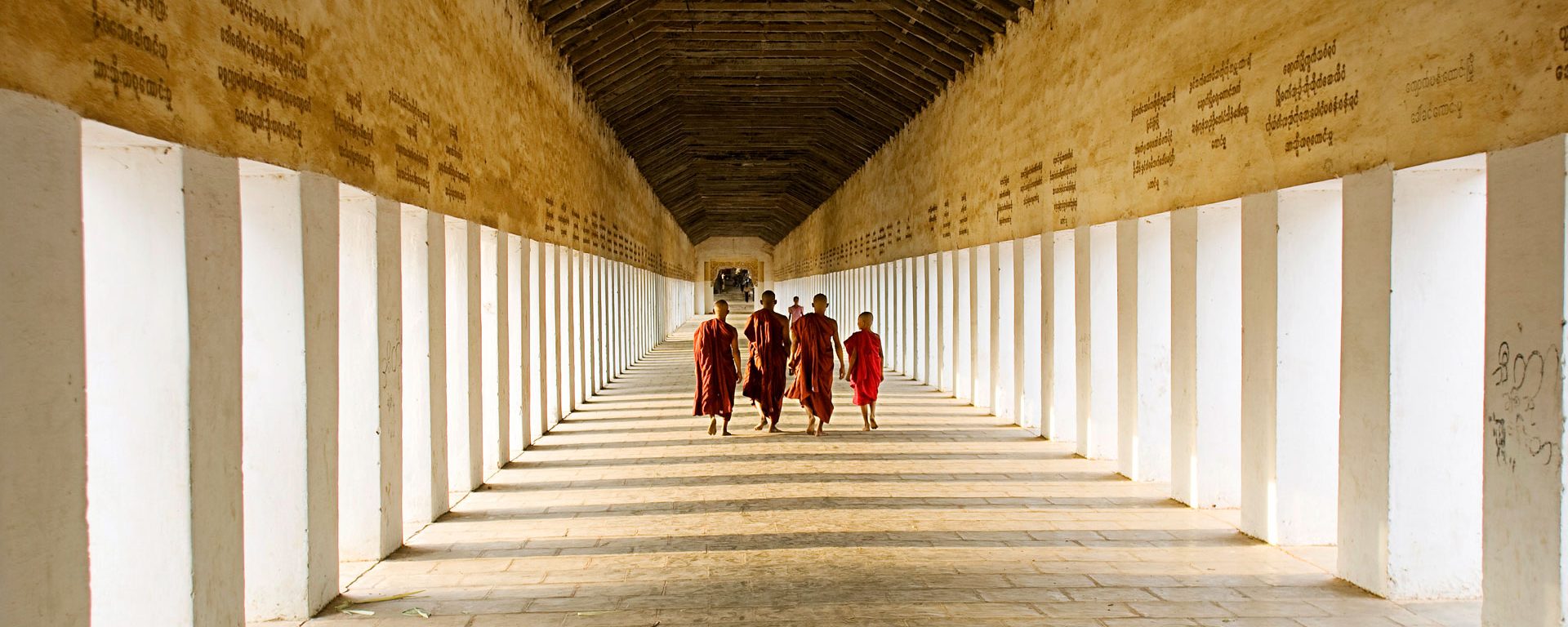 Young monks walking the hallway of Swezigon Pagoda near Bagan, Myanmar