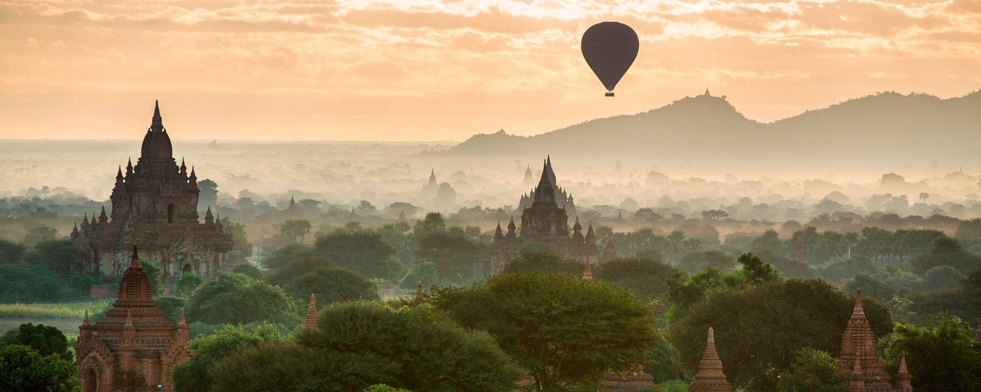 Hot air balloon flies over temples at dawn, Bagan, Myanmar