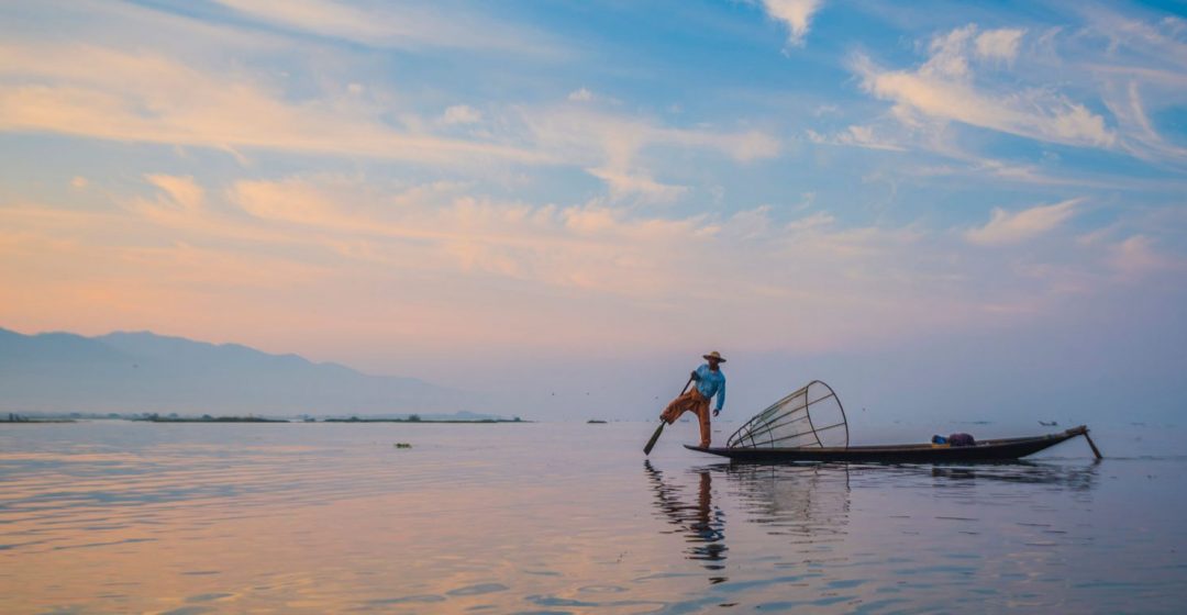 Local fisherman with typical conical fishing net on Inle Lake, Myanmar