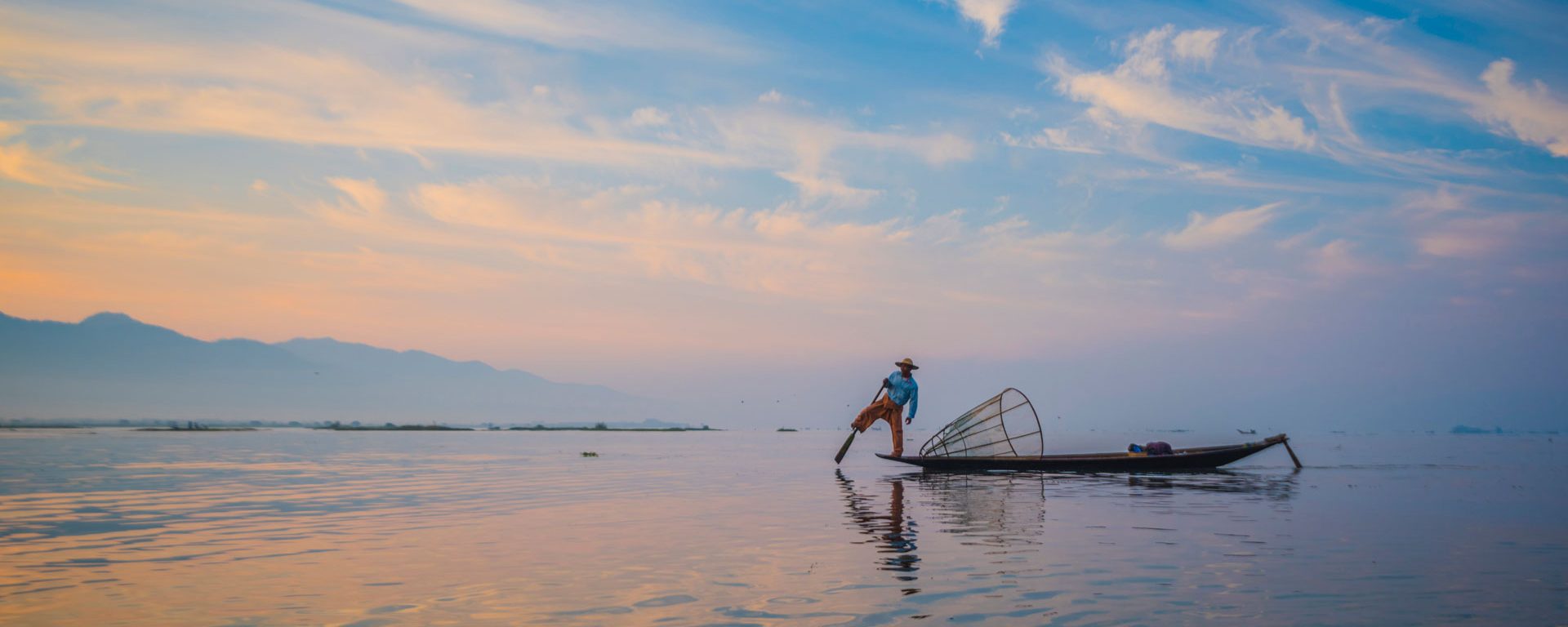 Local fisherman with typical conical fishing net on Inle Lake, Myanmar