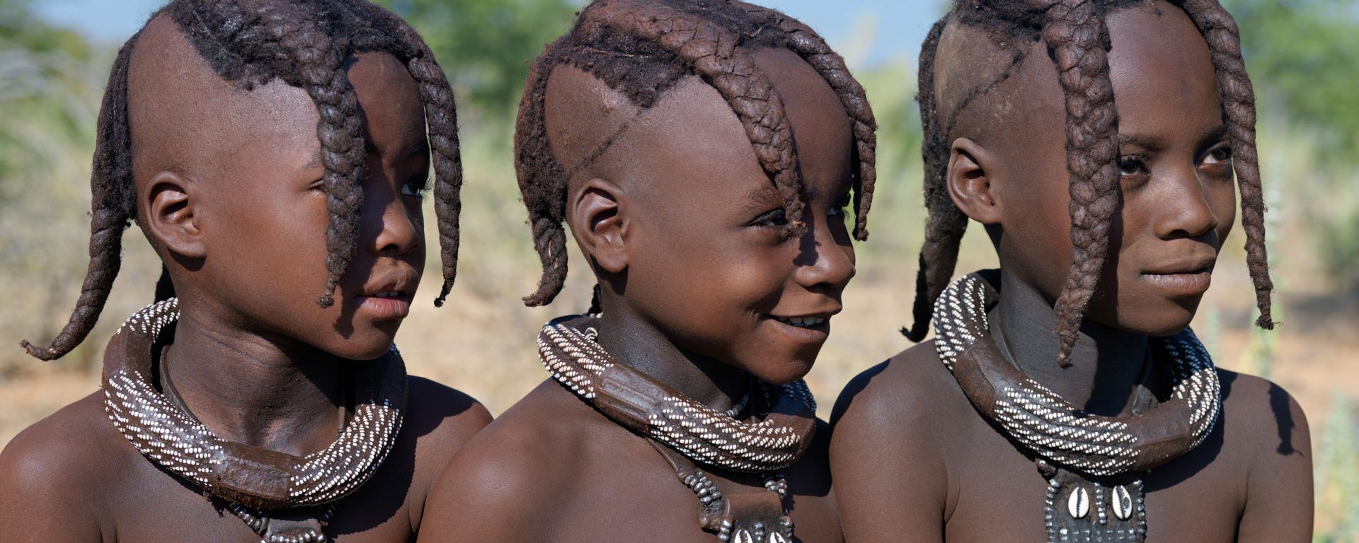 Three young Himba girls wearing necklaces, Namibia