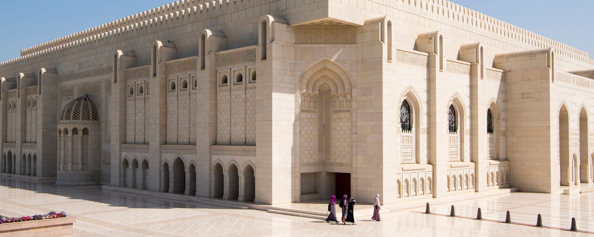 Omani women walking around the outside of the main Prayer Hall of The Sultan Qaboos Grand Mosque, Muscat, Oman