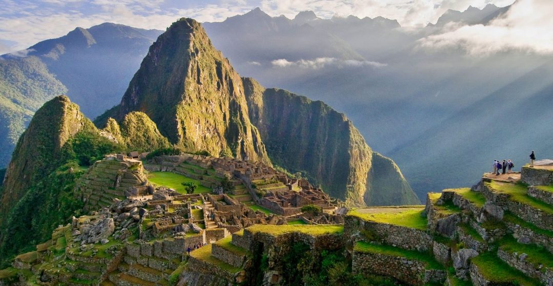 The suns rays break through the clouds illuminating Huayna Picchu, Machu Picchu, Peru