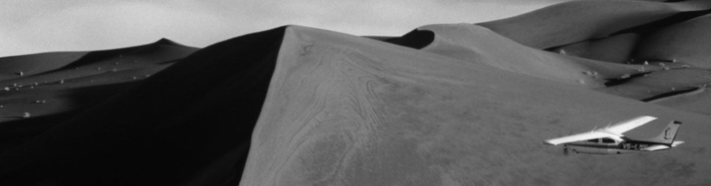 Safari flights over red sand dunes of Sossusvlei with early morning mist, Namib-Naukluft National Park, Namibia.