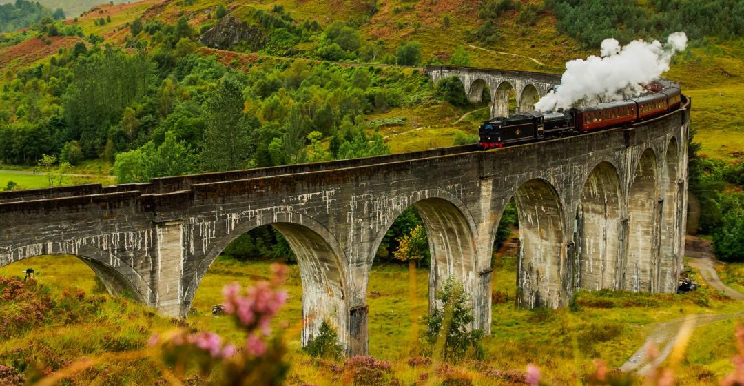 Jacobite Steam Train crossing the Glenfinnan Viaduct in Scotland, Highlands, UK