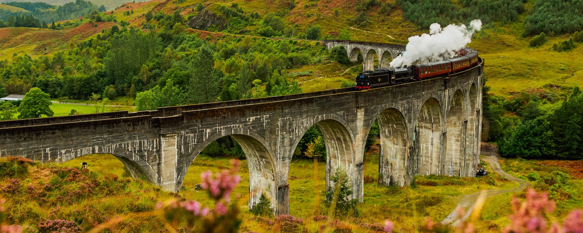 Jacobite Steam Train crossing the Glenfinnan Viaduct in Scotland, Highlands, UK