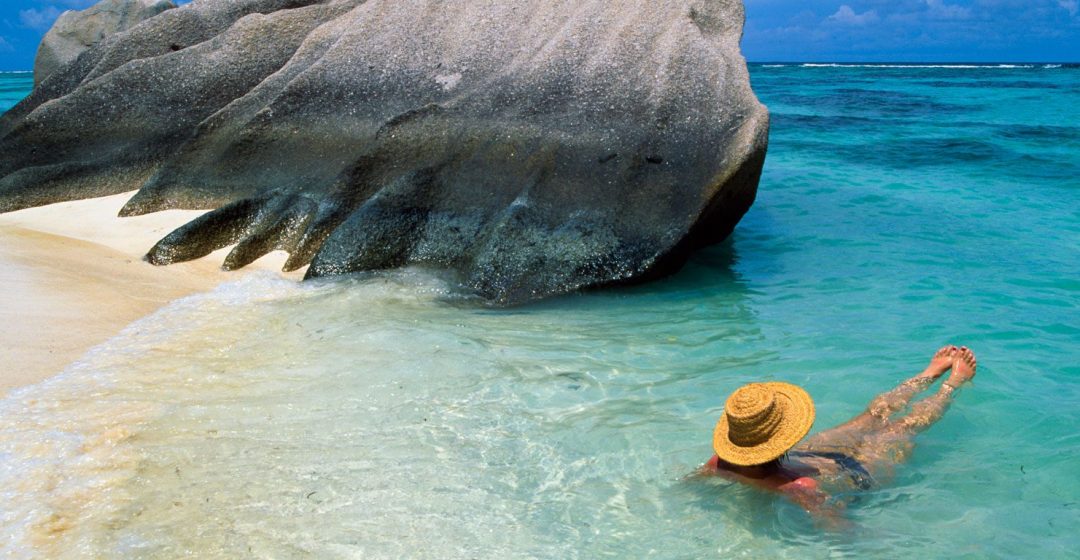 Woman swimming at beach on La Digue Island, Seychelles