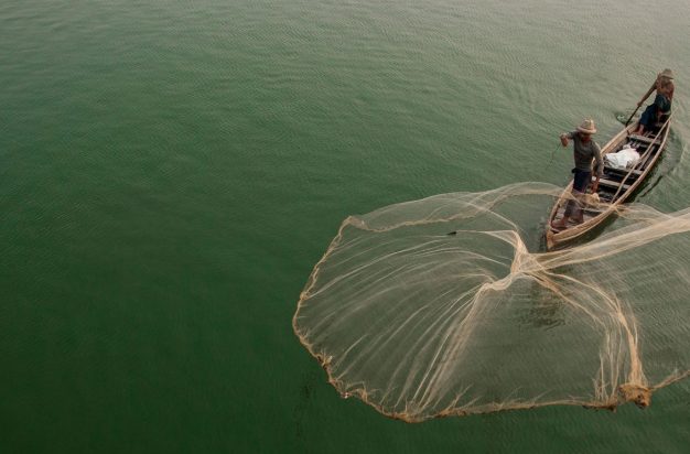 Myanmar, Mandalay, fisherman casting net on Irrawaddy River