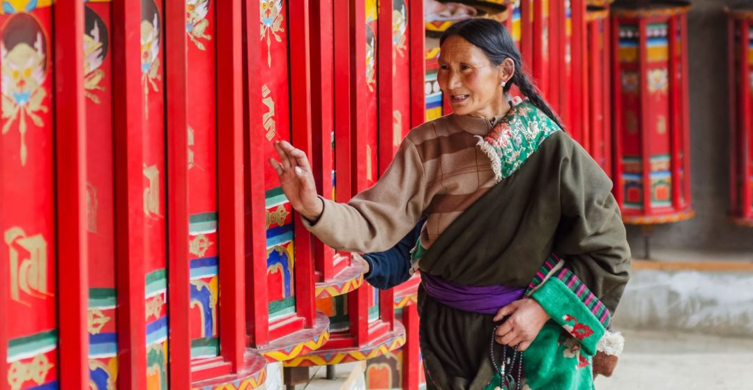 Praying by rotating prayer wheels at Longwu monastery, Tibet.