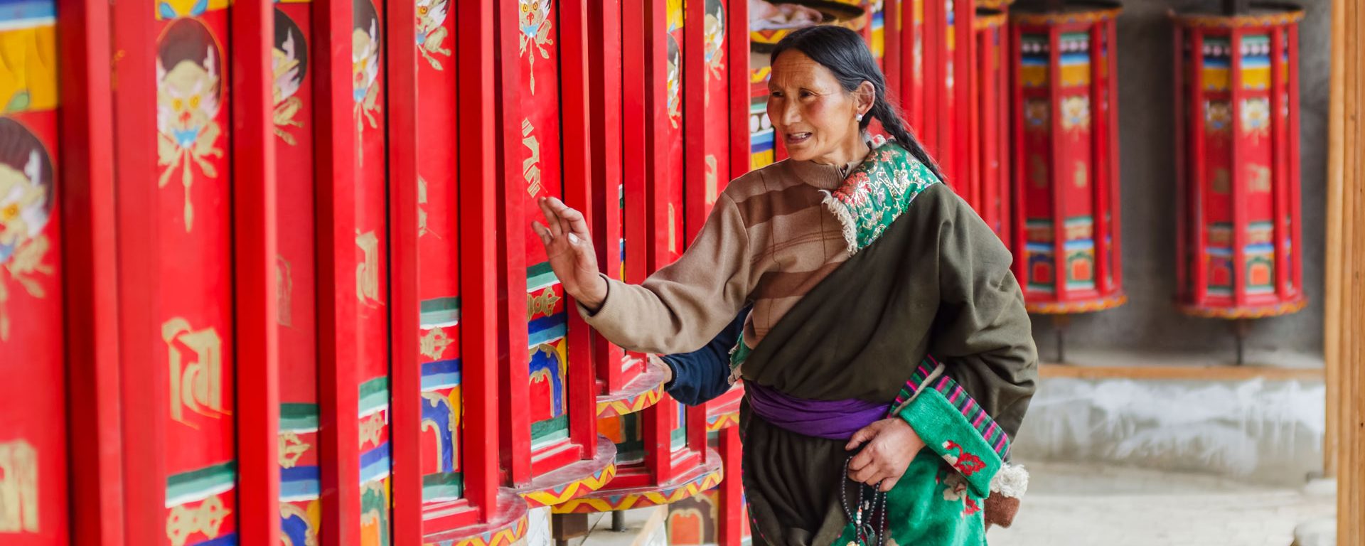 Praying by rotating prayer wheels at Longwu monastery, Tibet.