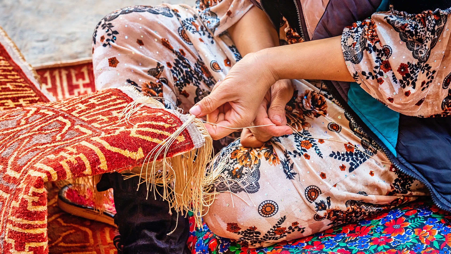 Carpet weaver weaving a typical oriental Uzbek silk carpet in Khiva, Uzbekistan