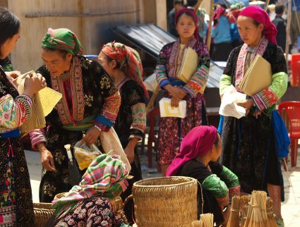 Women in tribal dress gather at a market in Ha Giang Province, Vietnam